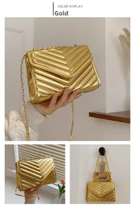 Detail of golden chevron quilted patent leather bag with a stylish metal chain strap