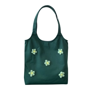 Minimalist dark green canvas tote bag featuring yellow and green crochet flower details