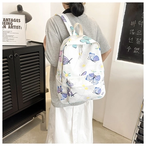White butterfly printed backpack showing a student style design with side pocket details