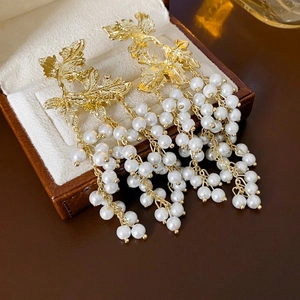 Elegant maple leaf gold tassel earrings with pearls on a premium jewelry display box