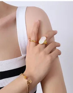 Dettaglio del set bracciale a catena dorata e anello con madreperla irregolare oro