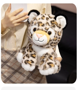 Detail of soft leopard plush toy held in hands showing realistic spots and fluffy texture