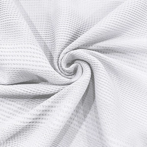 Gros plan du tissu gaufré blanc montrant la texture premium et le motif respirant
