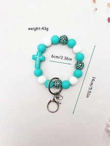 Close-up of leopard print silicone beads and Jesus cross pendant on wristlet keychain