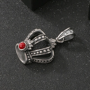 Detail of a vintage punk crown pendant with red bead inlay and sparkling rhinestones