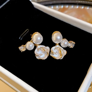 Détail de boucles d'oreilles fleur de perle et cristaux dans un écrin en velours noir