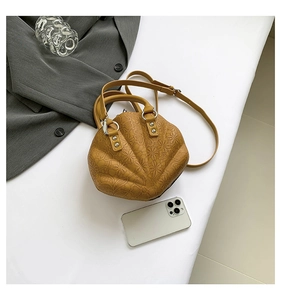 Detailed top view of a ginger yellow shell-shaped handbag with floral embossing patterns