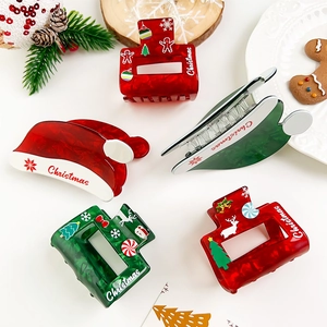 Detailed view of red Christmas hat hair claw clips and acrylic festive hair accessories