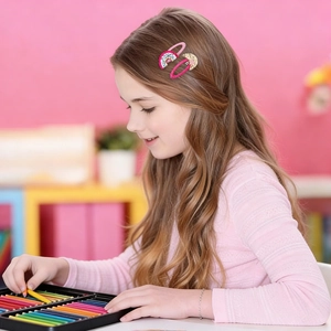Close-up of pink rainbow and gold glitter hair clips worn by a girl in a bright setting