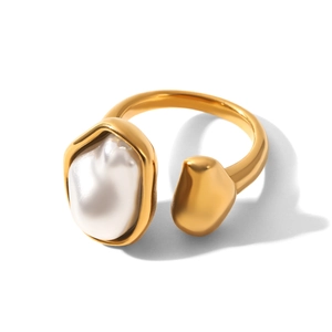 Macro detail of a golden open ring featuring a baroque pearl on a white background