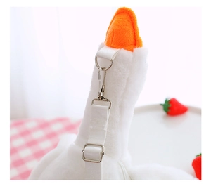 Detailed macro view of adjustable metal buckle and strap on white plush goose bag