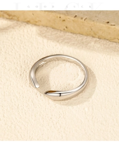 Detail of minimalist S925 sterling silver bypass ring with high-polished mirror finish