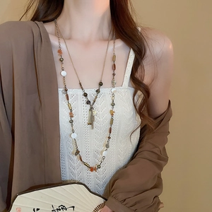 Dettaglio collana vintage con perline, nappe, tubi metallici e design etnico a più strati