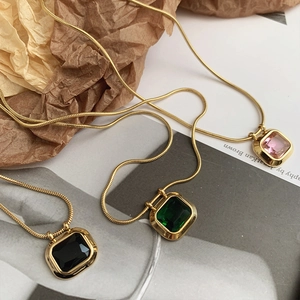 Detailed view of square zircon necklaces with snake chains in black, green and pink colors