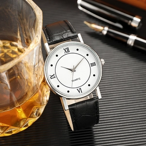 Classic men's quartz watch with white Roman dial and black leather strap on a desk