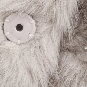Détail macro du revers de manteau en fausse fourrure avec bouton recouvert de tissu gris clair