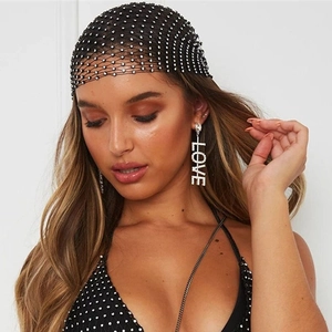 Close-up of black mesh headwrap with silver rhinestones and love letter earrings