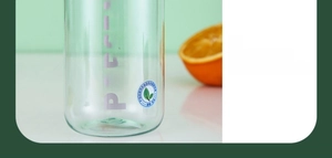 Détail de la gourde portable vert clair avec logo POPSTA et fond d'orange fraîche