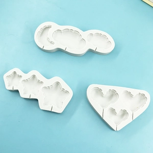 Macro shot of white silicone molds for moon, cloud, star and heart shapes on blue background
