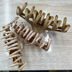 Detailed top view of three large octopus hair claws with artistic oil painting wood grain finish