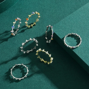Stackable S925 silver rings with colorful rainbow zircons on a dark green background