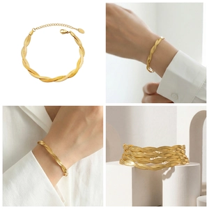 Detail of twisted gold snake chain bracelet with adjustable lobster clasp on white marble