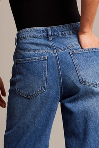Dettaglio della tasca posteriore e delle cuciture in vita di jeans in denim blu