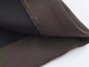 Detail of dark olive twill fabric with black lining and precise stitching craftsmanship