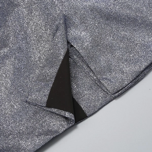 Detailed close-up of silver sequin fabric with black lining and precise edge stitching