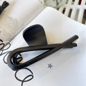Detail of a large matte black shark hair claw clip with a sleek minimalist finish