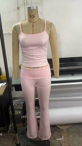 Dettaglio del set canotta rosa e pantaloni a zampa d'elefante su un manichino da sartoria