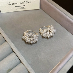 Close-up of hollow lace basket pearl earrings displayed in a luxury grey velvet jewelry box
