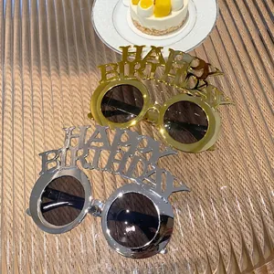 Metallic gold and silver Happy Birthday party sunglasses on a reflective glass table