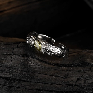 Lava texture silver ring with marquise yellow gemstone on dark wood, open band style
