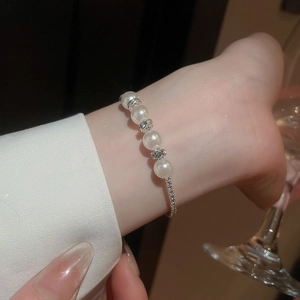 Macro detail of multilayer pearl bracelet with diamond spacers on an elegant wrist