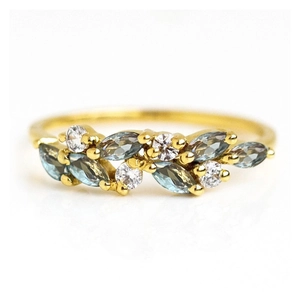 Minimalist gold leaf-shaped ring featuring blue marquise-cut stones and white zircon accents