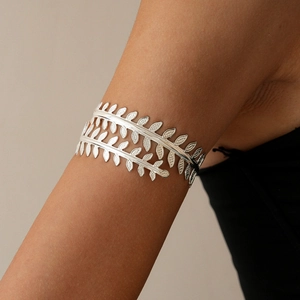 Close-up of minimalist silver leaf arm cuff with hollow branch design on upper arm