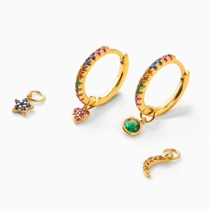 Macro shot of gold hoop earrings with colorful zircon moon and star charms set