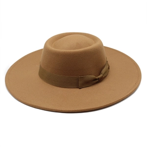 Détail du chapeau en feutre de laine marron avec ruban gros-grain et nœud décoratif