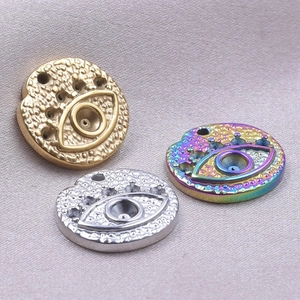 Detailed macro of devil's eye charms in gold, silver, and rainbow steel finishes