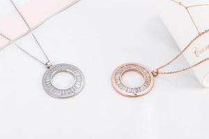 Detail of hollow round pendants in silver and rose gold with baguette cubic zirconia stones