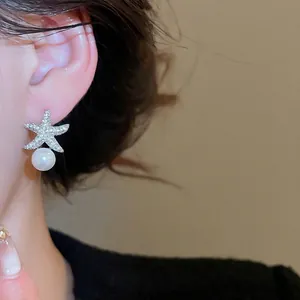 Élégantes boucles d'oreilles étoile de mer avec cristaux et perles sur mannequin