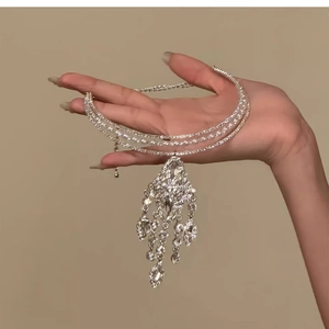 Detail of multi-layer silver choker with sparkling rhinestones, pearls and a tassel pendant