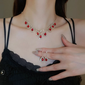 Detailed view of luxury red teardrop rhinestone necklace and earring set on model