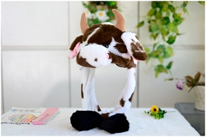 Detail of cute cow themed plush hat with moving ears and brown spots on white fur