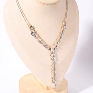 Primo piano dettagliato di una collana a frangia a Y bicolore con vari zirconi geometrici
