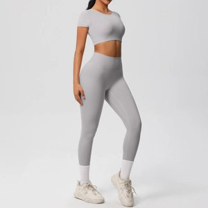 Vue latérale de l'ensemble de yoga gris clair avec haut court et legging élastique