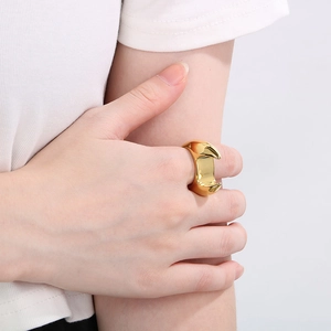 Close-up of chunky geometric 18K gold plated stainless steel ring worn on index finger