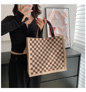 Close-up of checkered linen tote bag held by model showing spacious storage capacity