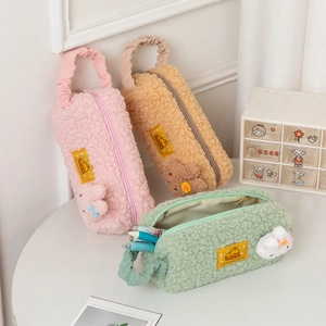 Plush cartoon pencil cases in pink, khaki, and green colors with cute 3D animal charms